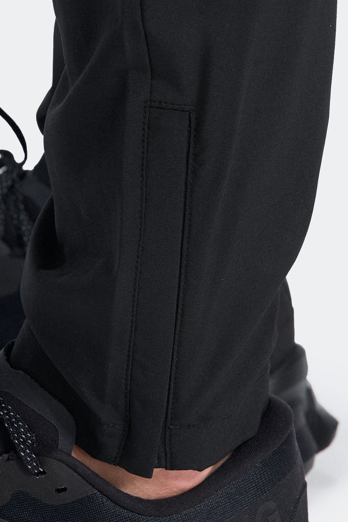 Trail Panel Running Pant - Black/Navy/Blue — Adjustable hem with a zip for a customisable fit.
